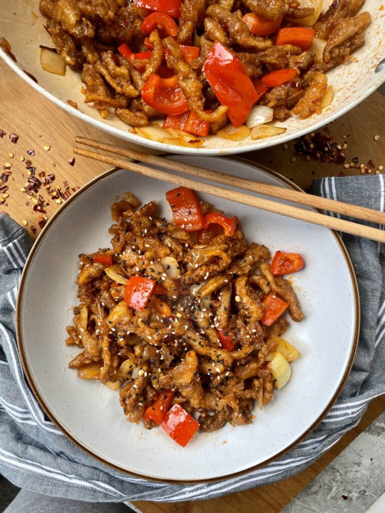 Crispy battered and fried oyster mushroom strips with red peppers and onions in a sticky sweet chilli sauce