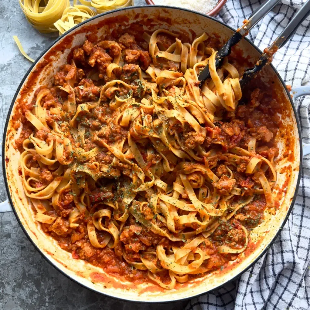 Smokey aubergine and vegetable protein pieces in a rich tomato sauce stirred into tagliatelle pasta