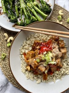 Tempeh chunks in a sweet sticky chinese style sauce with cashew nuts, onions and red peppers. Served on a bed of rice sprinkled with sesame seeds alongside a plate of stir fried broccoli