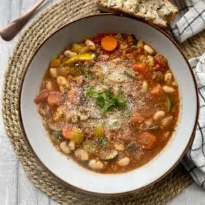 White beans, mixed vegetables and orzo pasta cooked in a herby tomato broth topped with vegan parmesan and a fresh herb garnish