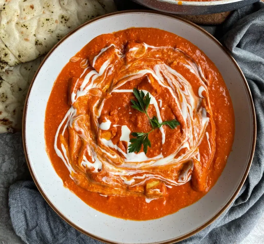 Tempeh pieces in a rich dark orange tikka masala sauce drizzled with a vegan cream topping