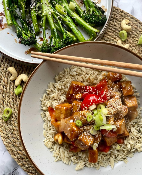 Tempeh chunks in a sweet sticky chinese style sauce with cashew nuts, onions and red peppers. Served on a bed of rice sprinkled with sesame seeds alongside a plate of stir fried broccoli