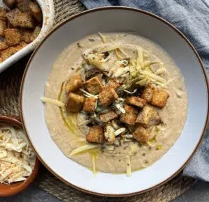 Roasted cauliflower cheese soup topped with croutons, herbs and a drizzle of olive oil
