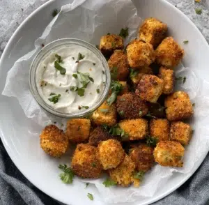 Tofu pieces coated in a crunchy breadcrumb served with a garlic mayonnaise and garnished with fresh parsley