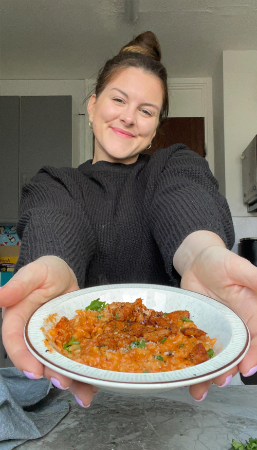 Abbie the website owner, smiling and holding a bowl of spicy orzo {{brizy_dc_image_alt imageSrc=