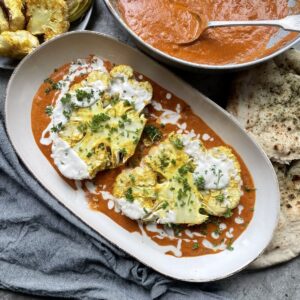 Slow roasted cauliflower steaks in a rich tomato Indian style butter sauce