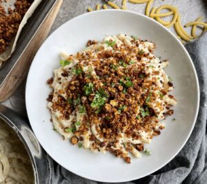 Macaroni pasta in a creamy sauce topped with smokey bacon crumbles and fresh parsley garnish