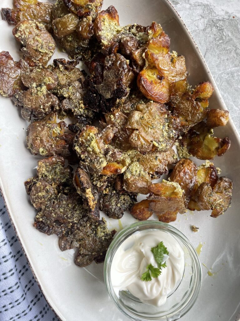Crispy roasted smashed new potatoes coated in wild garlic oil and parmesan served with a vegan mayonnaise