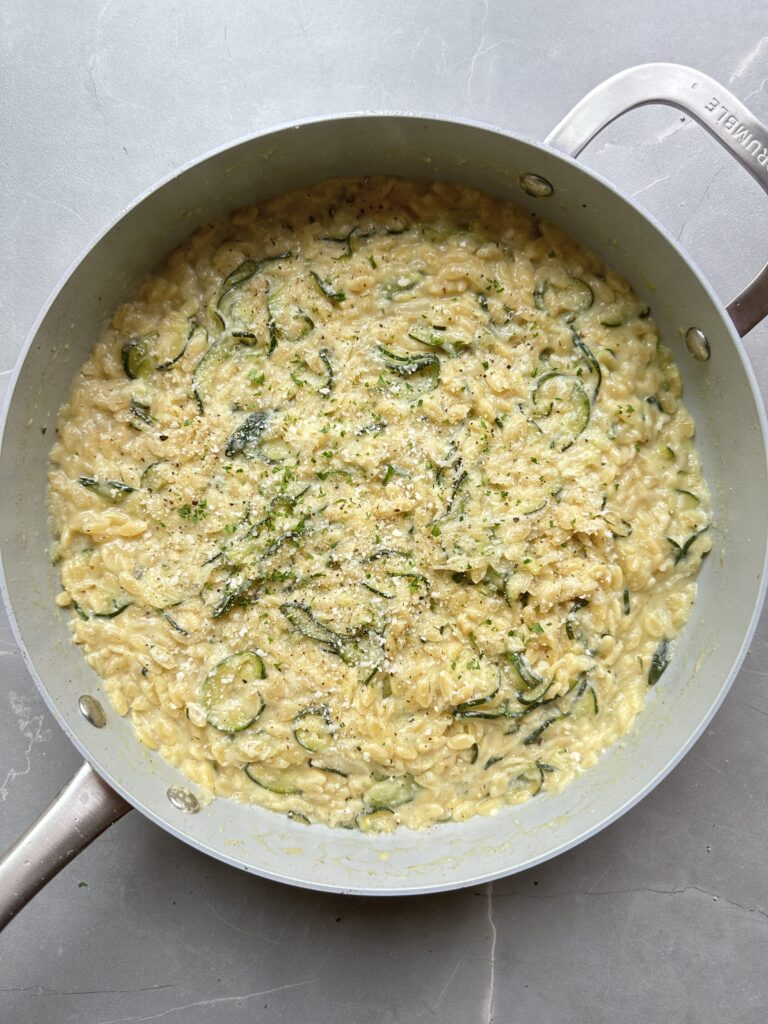 Final image of cooked courgette orzo garnished with parmesan and fresh parsley