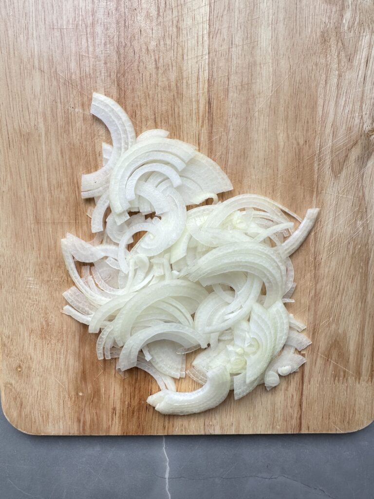 step two of cooking courgette orzo, thinly slice onion