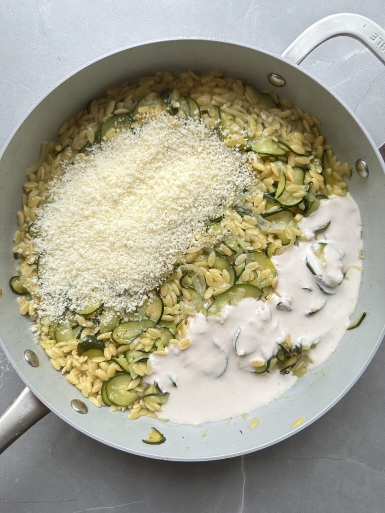 step ten of cooking courgette orzo, add parmesan and cream