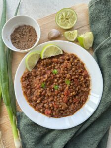 final image and main image of jerk lentils dish in a white bowl with slices of lime and spices on the side