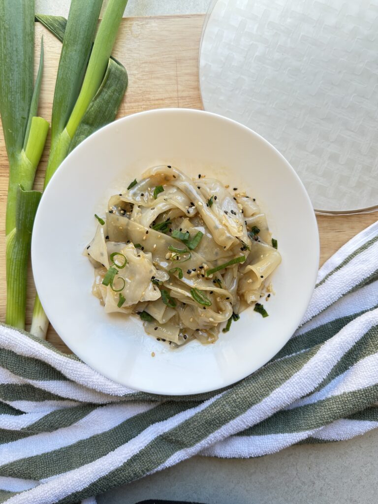 final image of rice paper noodles with spring onions and rice paper on the side