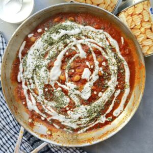 Spiced tomato based indian curry sauce with butter beans. topped with a cream drizzle and served with naan